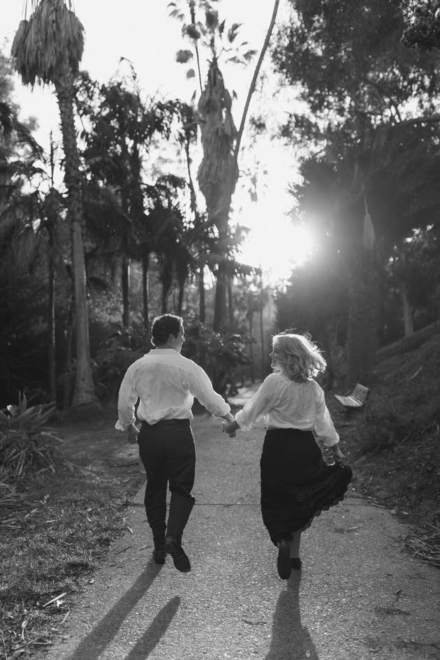 couple running together into a sunset in san diego in balboa park